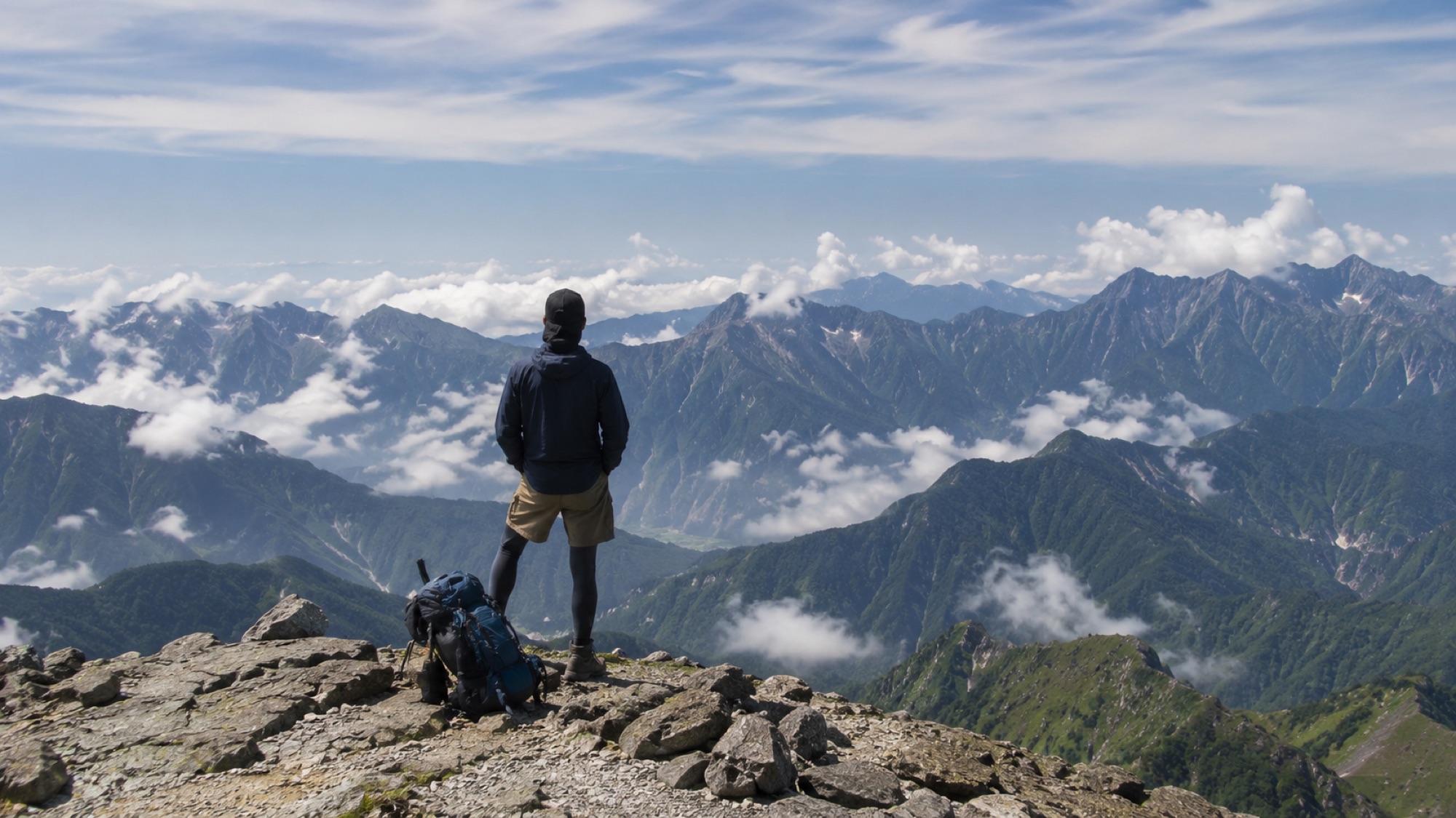 頂上で絶景を眺める登山者